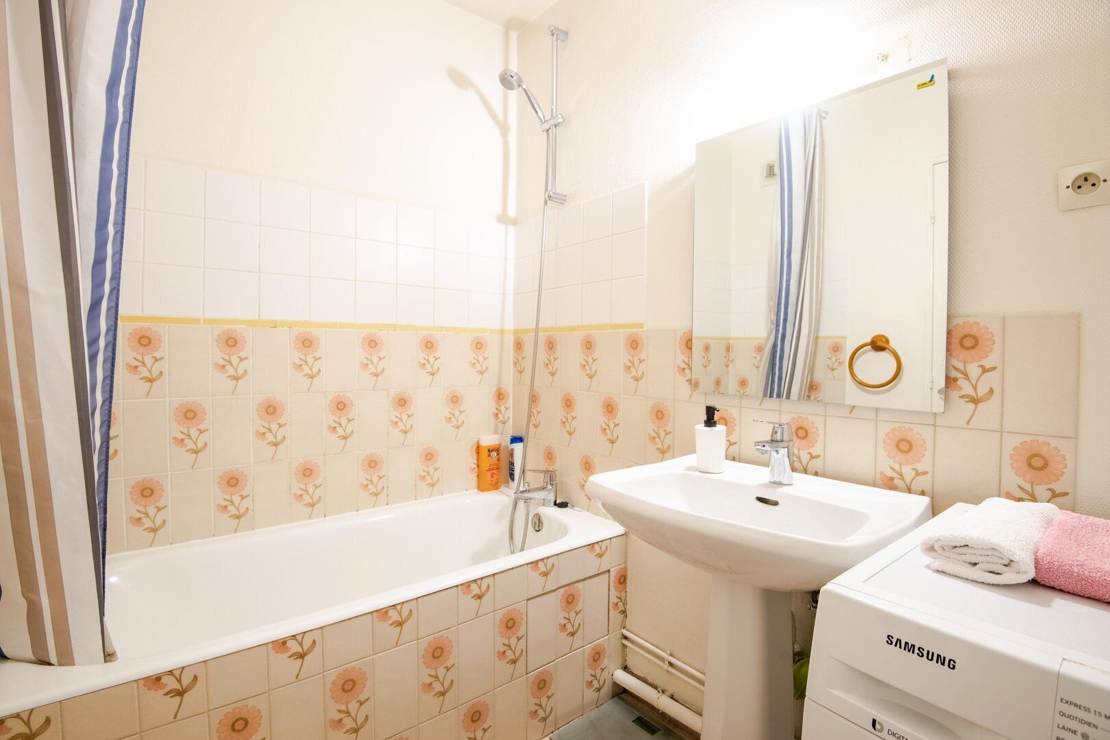 Un baño con bañera, lavamanos y espejo.