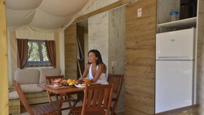 A wooden interior with a dining table, chairs, a sofa, and a refrigerator. - ZEcamping 4 étoiles animé pataugeoire dog friendly locatif clim 40m2 (Alghero)