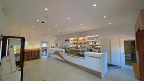 A modern interior with a reception desk, seating area, and a display of products.