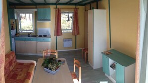 Een compacte keuken met een eethoek, een bank en een kleine tafel met een plant.