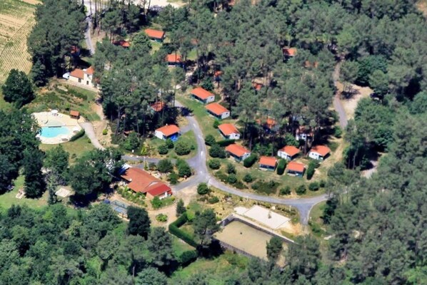 Vista aérea de una zona residencial con casas, piscina y un amplio campo abierto.