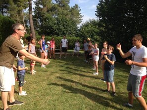 Un groupe de personnes se trouve à l’extérieur, peut-être dans un parc ou une zone de loisirs.