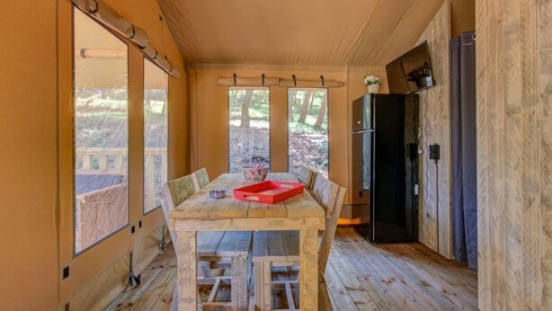 A wooden interior with a table, chairs, and a red tray.