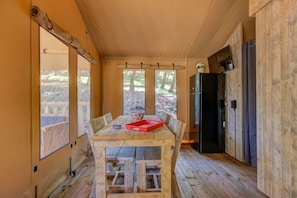 Een houten interieur met een tafel, stoelen en een rode dienblad.