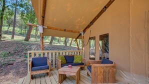 A covered outdoor seating area with wooden furniture and a canopy.