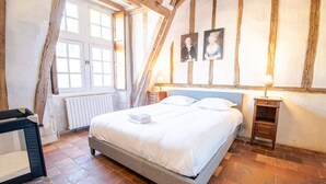 A bedroom with a bed, a nightstand, a dresser, and a window with curtains. - 16th century hunting lodge - Château de Nitray (Athée-sur-Cher)