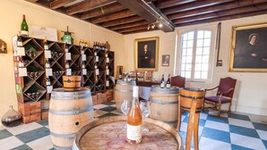 A wine cellar with wooden barrels, wine racks, and a checkered floor. - 16th century hunting lodge - Château de Nitray (Athée-sur-Cher)
