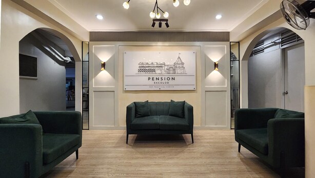 A modern lobby with a green sofa, two armchairs, and a framed artwork titled "PENSION BACOLOD". - Pension Bacolod (Bacolod)