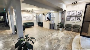 A reception area with a reception desk, a green sofa, and a potted plant. - Pension Bacolod (Bacolod)