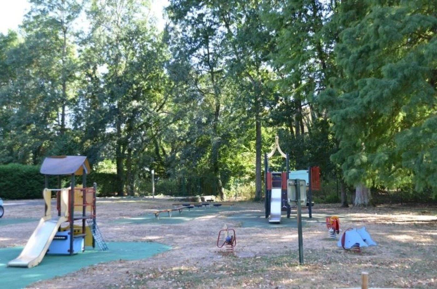Une aire de jeux avec un toboggan, des structures d’escalade et un espace de repos abrité.