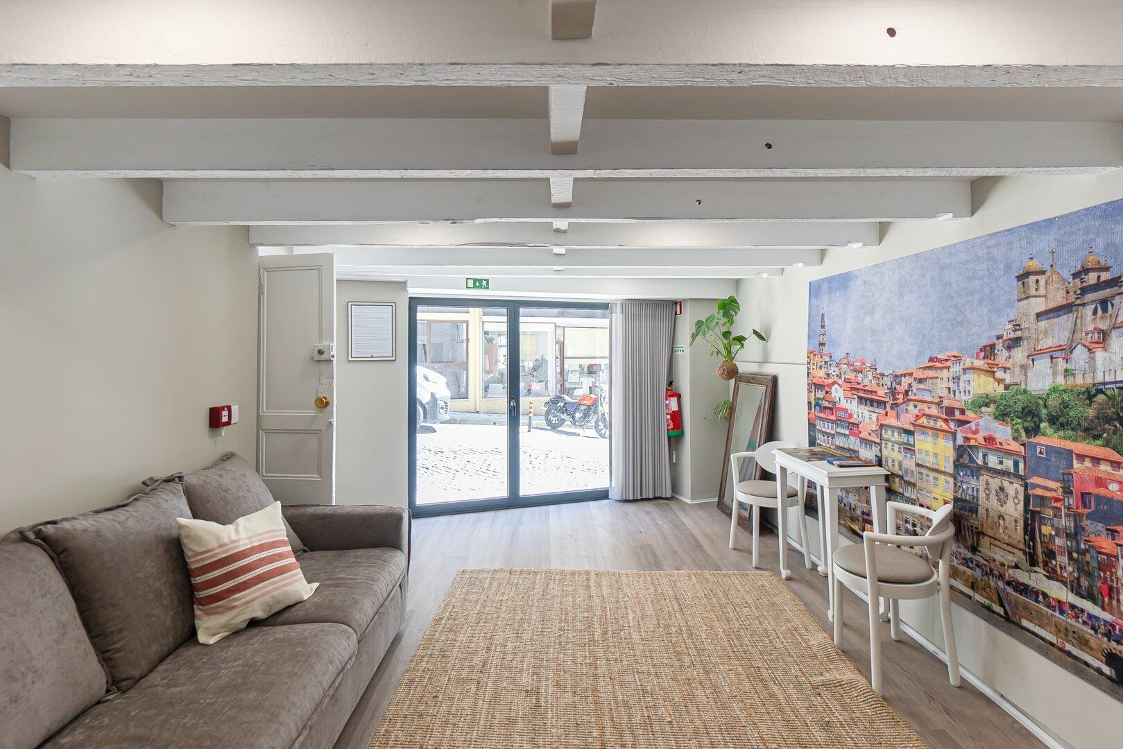 Un hall d’hôtel moderne avec un canapé, une petite table et une grande fresque murale.