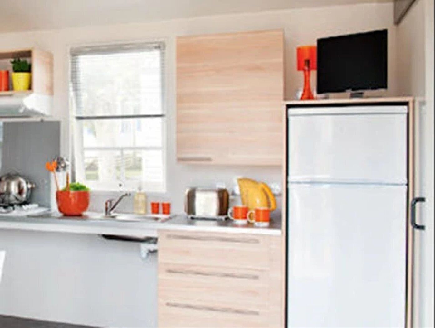 Eine moderne Küche mit Kühlschrank, Mikrowelle, Spüle und einem Fenster.