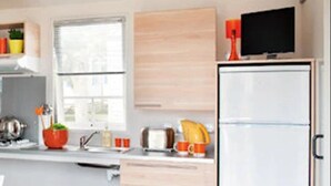 Eine moderne Küche mit Kühlschrank, Mikrowelle, Spüle und einem Fenster.