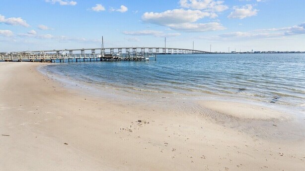 A beach with a pier extending into calm waters, sandy shore, and a clear sky. - Walk to Sound + Dining | Fenced Yard | Extended Stays Welcome Pet Friendly (Morehead City)
