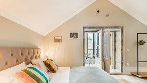 Ein Schlafzimmer mit einem großen Bett, einem Balkon und Blick auf die Stadt.