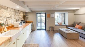Eine moderne Küche mit einer Steinwand, einer Holz Arbeitsplatte und einer Schiebetür zum Außenbereich.