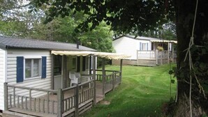 Une rangée de maisons mobiles dotées de terrasses en bois et bordées d’une pelouse.