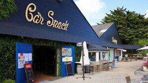 A bar named 'Bar Snack' with outdoor seating and a Coca-Cola refrigerator.