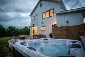 Una casa grande con jacuzzi en el patio trasero.