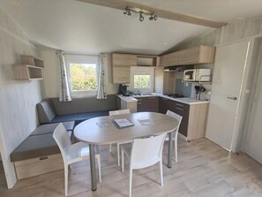 Una cocina compacta con comedor, un banco integrado y un ventanal que proporciona luz natural.