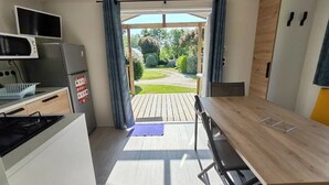Una cocina con comedor, vista al jardín y una mesa de madera.