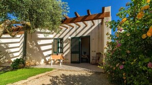 Ein modernes Haus mit Terrasse, einem Esstisch und Stühlen.