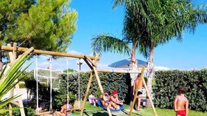 Un columpio de madera en un jardín con cielo despejado.
