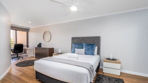 Ein modernes Schlafzimmer mit einem großen Bett, einem Schreibtisch und einem Stuhl.