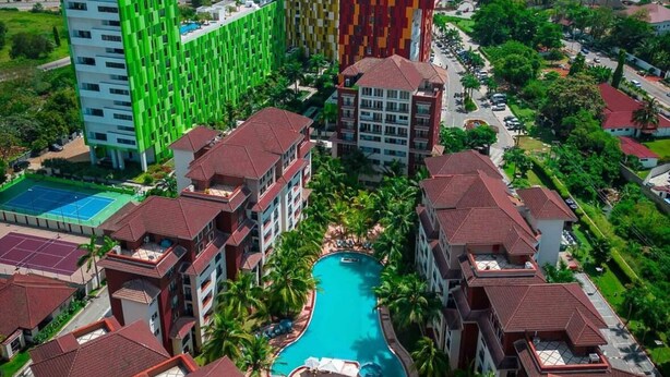 Een resort met meerdere gebouwen, een zwembad en palmbomen.