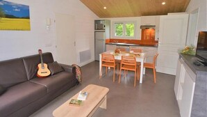 A compact living space with a kitchenette, a dining area, and a sofa.