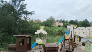 Ein Kinderspielbereich mit einer spielkonstruktion zum Thema Zug, inklusive eines Zugwagens, einer Rutsche und einer Kletterleiter.
