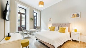 Una habitación de hotel con cama, mesitas de noche, escritorio y silla.