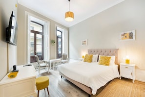 Une chambre d’hôtel avec un lit, des tables de chevet, un bureau et une chaise.