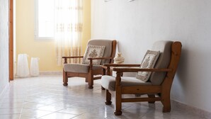 A room with two wooden chairs, a small table, and a window with sheer curtains. - Casa Duesse (IUN R6224)Accommodation located in the very center of Orosei. (Orosei)