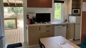 A compact kitchen with a dining area, a microwave, and a stove.
