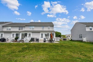 A residential building with a front porch, a covered patio, and a well-maintained lawn. - Townhome with community pool, tennis court, and only 2 miles from Bethany Beach! (Frankford)