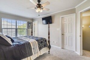 A bedroom with a bed, a ceiling fan, a TV mounted on the wall, and a door. - Townhome with community pool, tennis court, and only 2 miles from Bethany Beach! (Frankford)