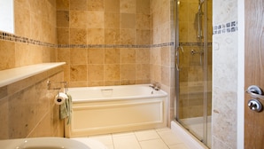 A bathroom with a bathtub, shower, and toilet.