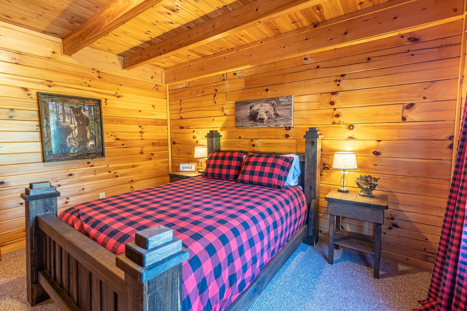A cozy wooden cabin bedroom with a bed, two nightstands, and a night lamp.