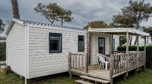 Une petite cabane à un seul étage, dotée d’un porche et d’un espace salon abrité.