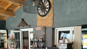 Una cocina moderna con encimera de madera, una cafetera y un reloj en la pared.