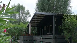 Ein Holzhaus mit einer Veranda und einem Schotterweg.