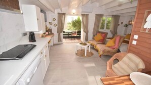 Un espacio habitable compacto con kitchenette, comedor y zona de estar.