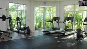 A gym with treadmills, elliptical machines, and a weight bench. - Amazing Apt for 10, big beach, private pool jacuzzi & BBQ, fully equipped (Playa del Carmen)
