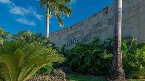 A hotel entrance with a palm tree and a sign that reads "Mareazul". - Amazing Apt for 10, big beach, private pool jacuzzi & BBQ, fully equipped (Playa del Carmen)