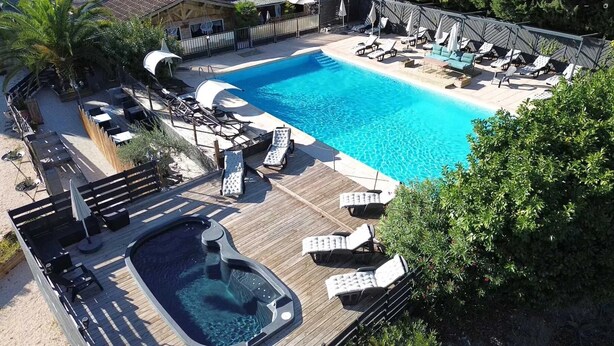 Une piscine avec des chaises longues et un jacuzzi.