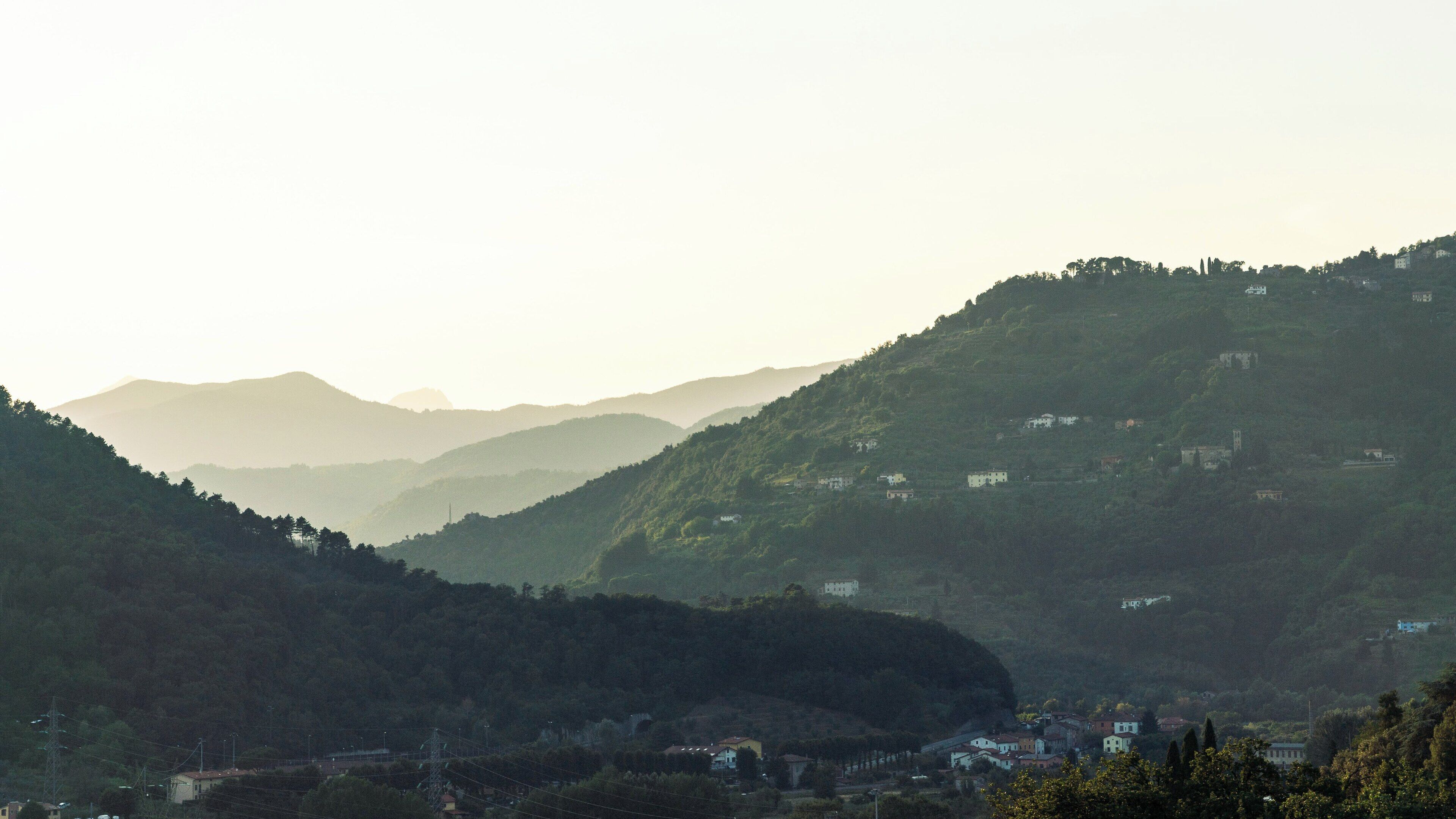 A mountainous landscape with scattered houses and a clear sky.