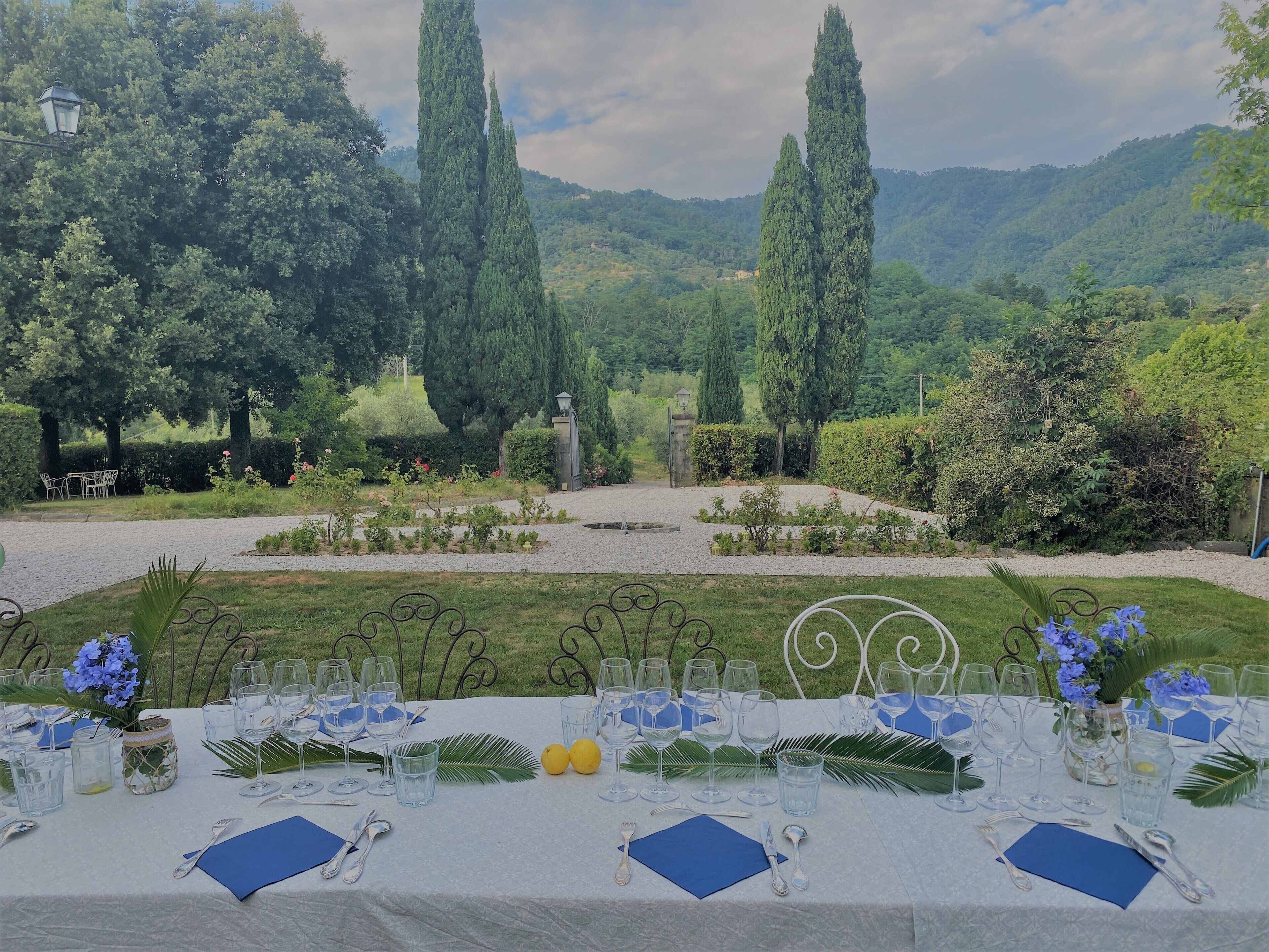 A table set for a formal outdoor event with a scenic mountainous backdrop.