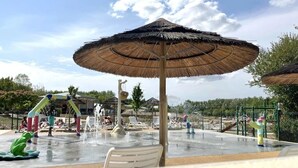 A water park with a large umbrella, water play area, and seating.