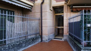 A narrow alleyway with a metal fence on one side and a building entrance on the other. - Una Palma a Camogli by Wonderful Italy (Camogli)